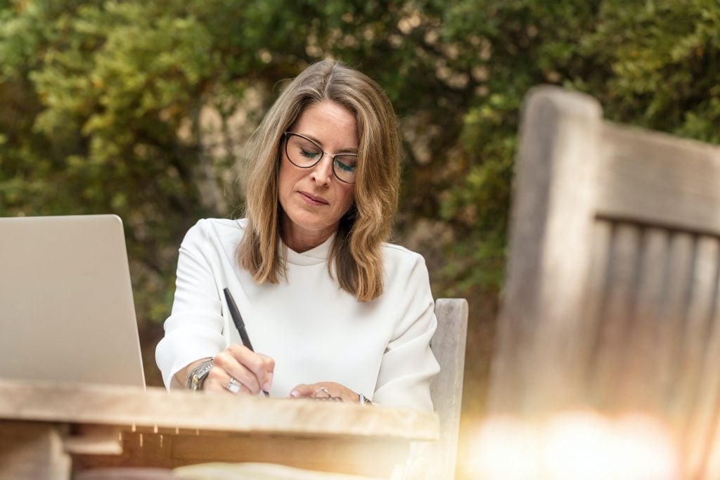 A woman working outside on her laptop