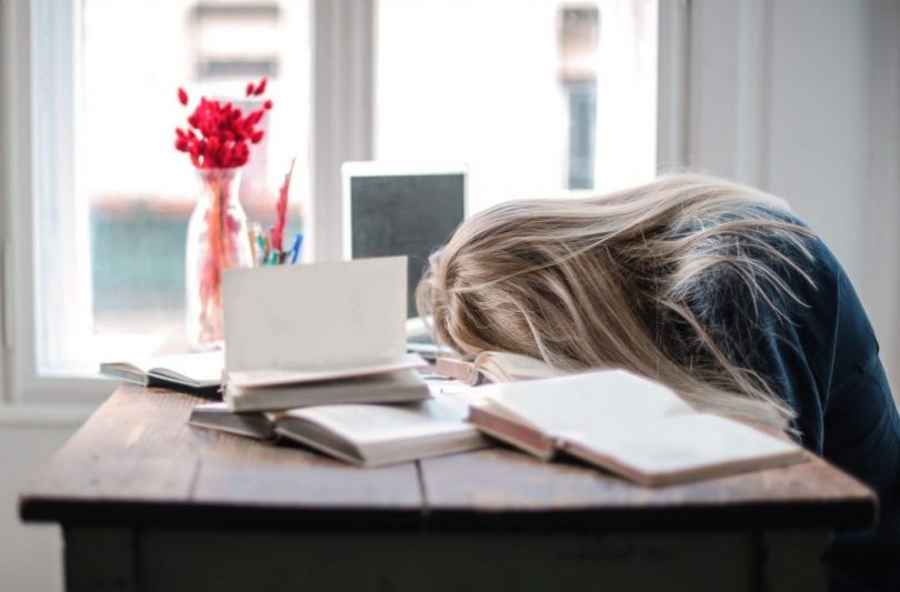 A woman with her head on the desk, unengaged