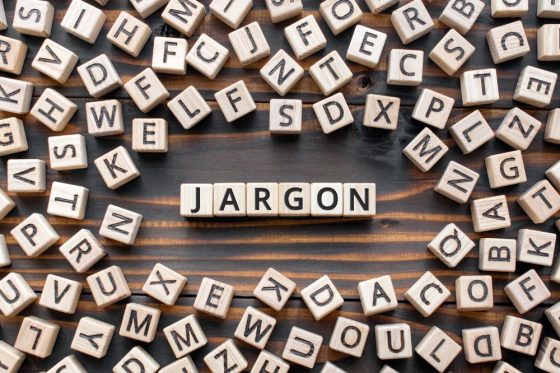 Many Scrabble tiles are scattered on a table; in the middle, they spell out "Jargon"