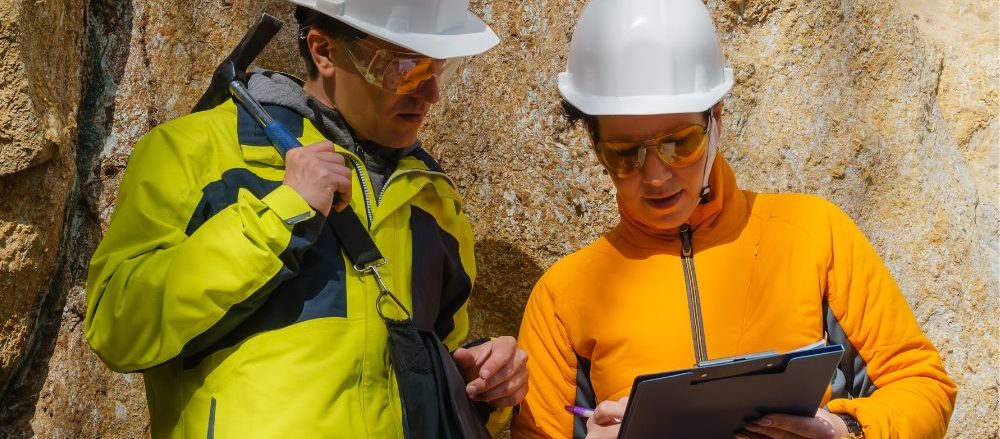 Two geoscientists consulting a tablet.