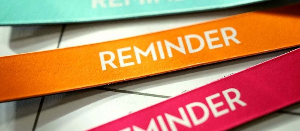 3 colourful strips of paper that say "reminder"