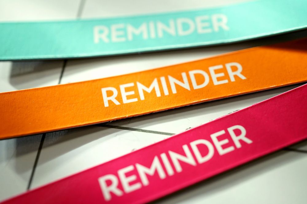 3 colourful strips of paper that say "reminder"