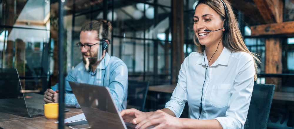 A woman working in technical support happy answers questions over the phone