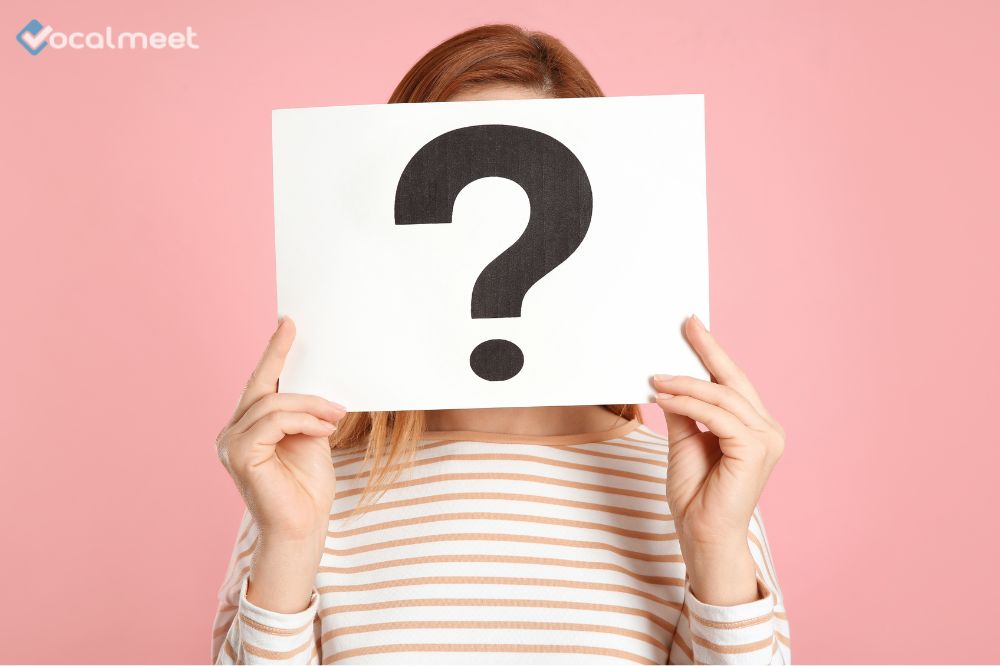 Woman holding a question mark in front of her face