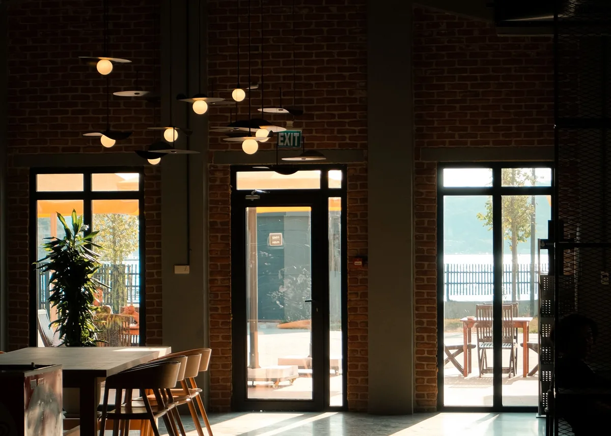 Sunlight crosses a large open room with a shared table and chairs.