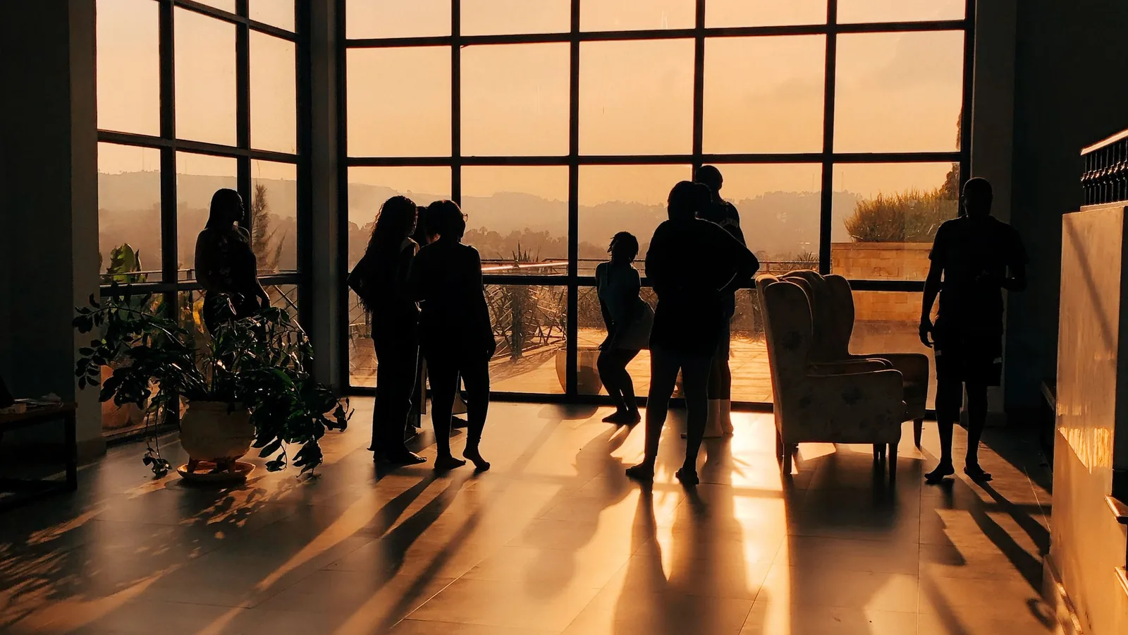 A small group stands together in a sunlit modern interior.