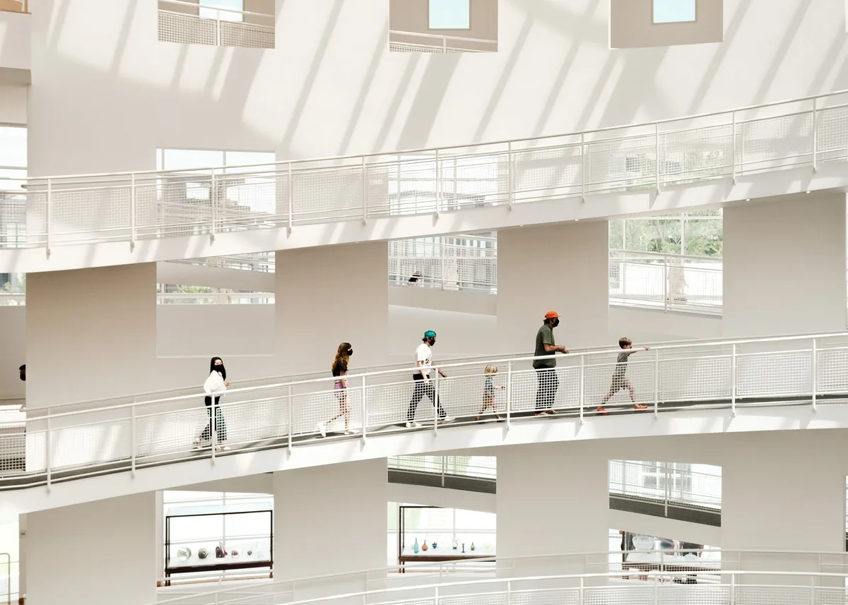 People move between open levels in a light-filled modern building.