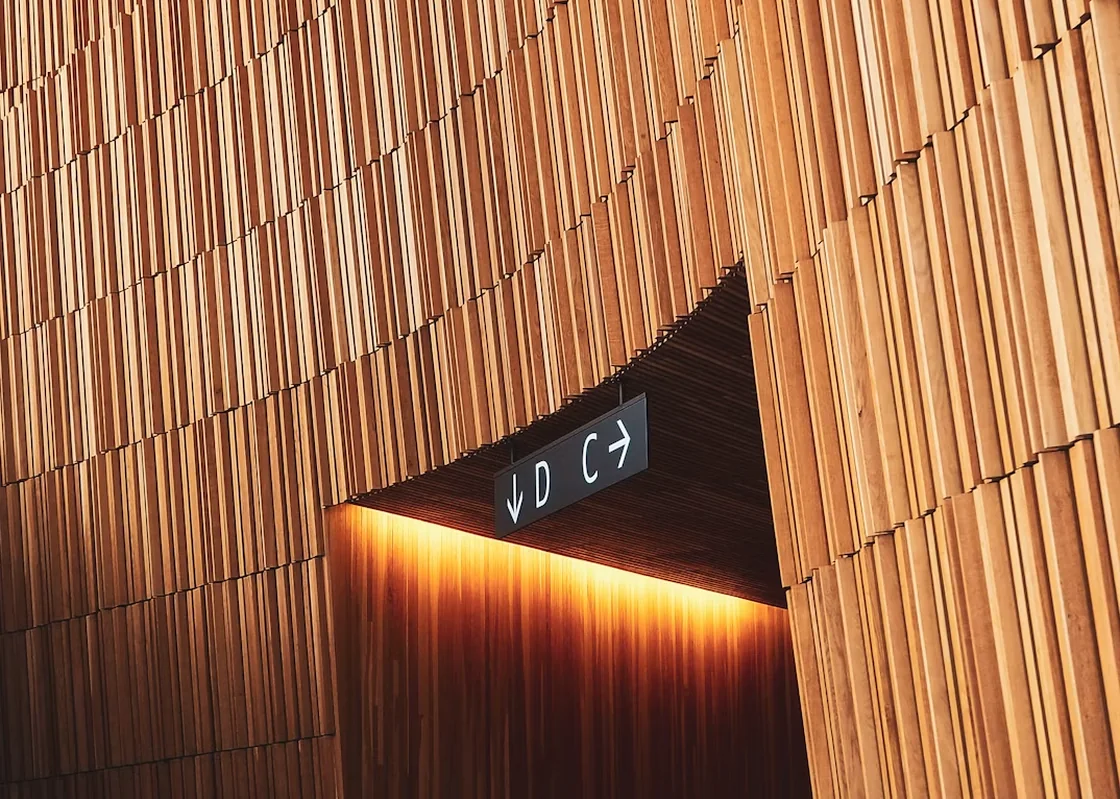 Warm architectural wayfinding sign pointing toward the next step.