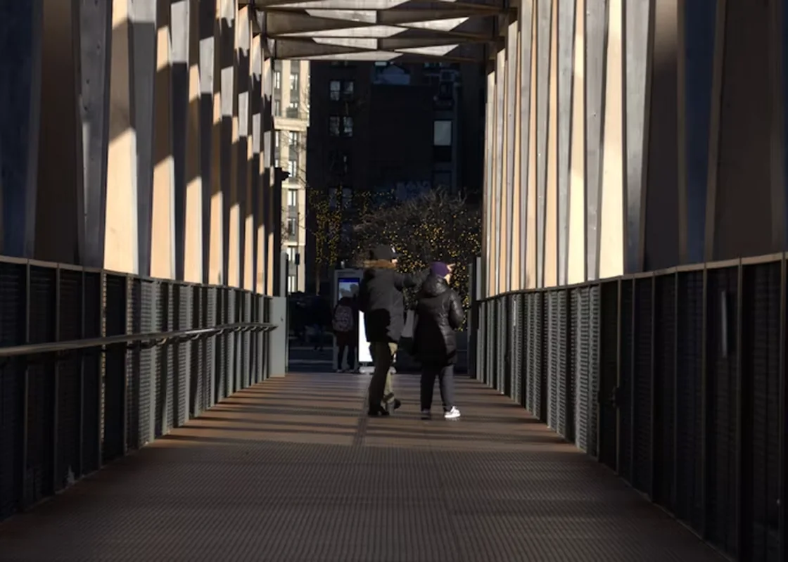 People walking together across a modern pedestrian bridge.
