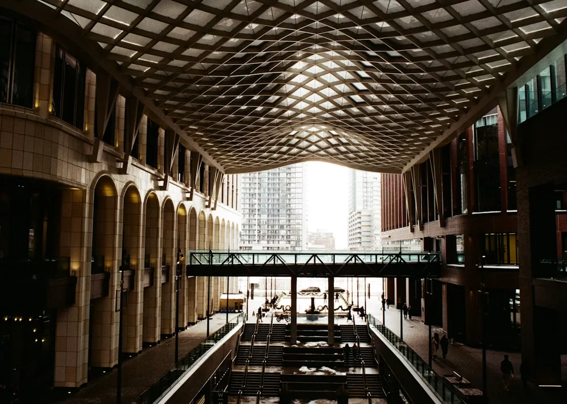 Sunlit atrium walkway inside a modern building.