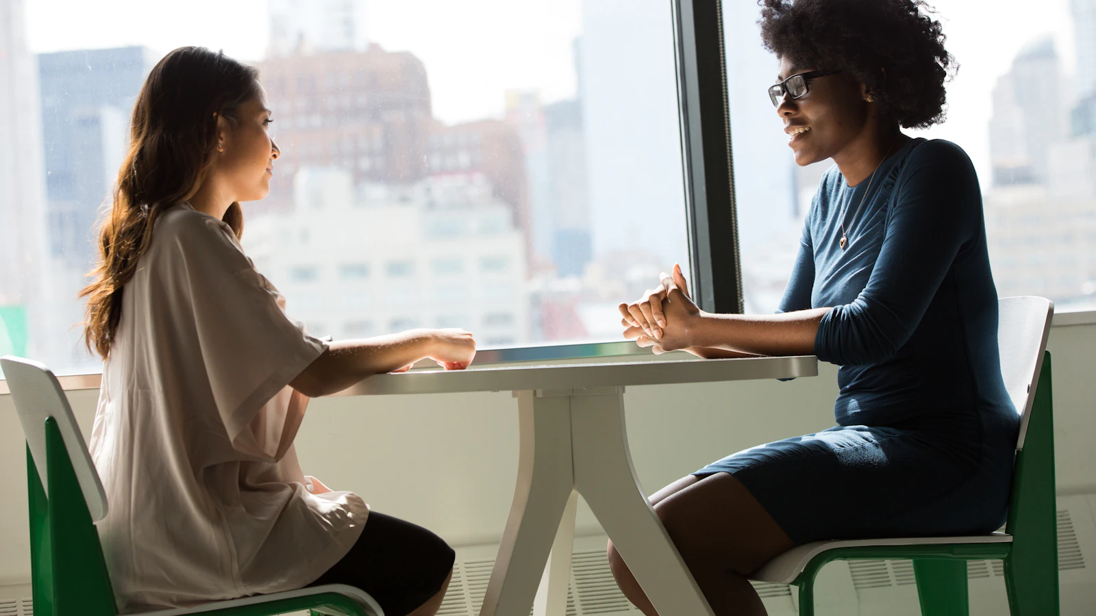 Two association professionals sharing experience during a one-to-one conversation in a bright office.